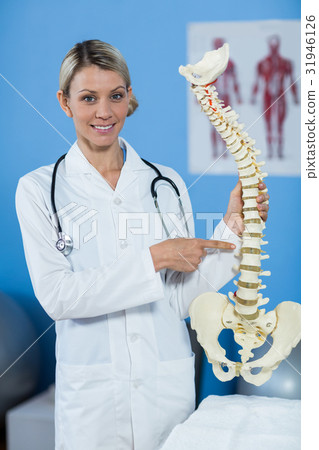 Portrait of physiotherapist holding spine model Portrait of physiotherapist holding spine model 31946126