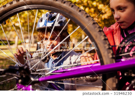 Siblings repairing mountain bike Siblings repairing mountain bike 31946230