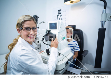 Female optometrist examining young patient on coreometry Female optometrist examining young patient on coreometry 31946235
