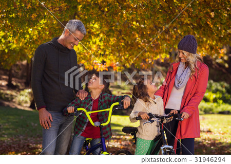 Happy children riding bicycles with parents 31946294