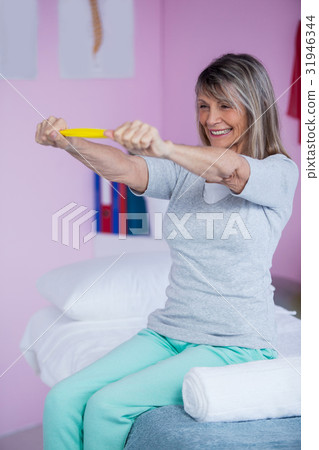 Senior woman exercising with exercise band 31946344
