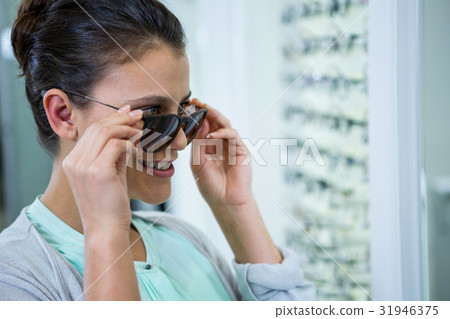 Smiling female customer trying spectacles 31946375