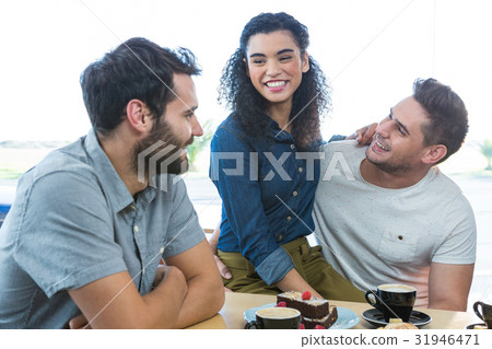 Friends interacting with each other in coffee shop Friends interacting with each other in coffee shop 31946471