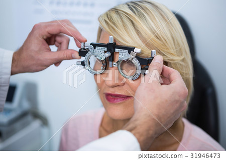 Optometrist examining female patient with messbrille Optometrist examining female patient with messbrille 31946473