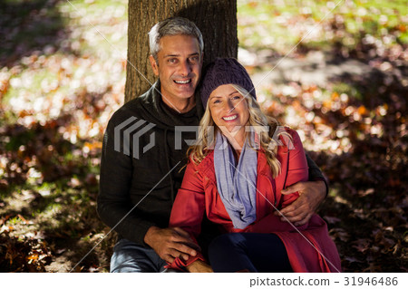 Portrait of couple sitting under tree Portrait of couple sitting under tree 31946486