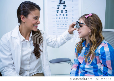 Female optometrist examining young patient with trial frame Female optometrist examining young patient with trial frame 31946487