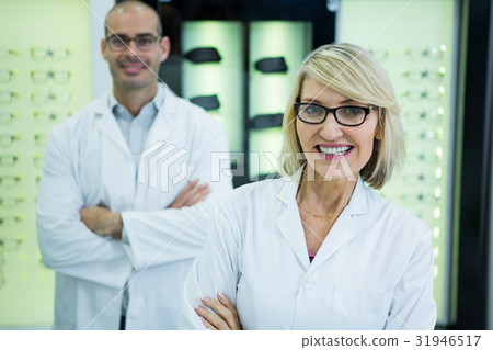 Smiling optometrists standing with arms crossed Smiling optometrists standing with arms crossed 31946517