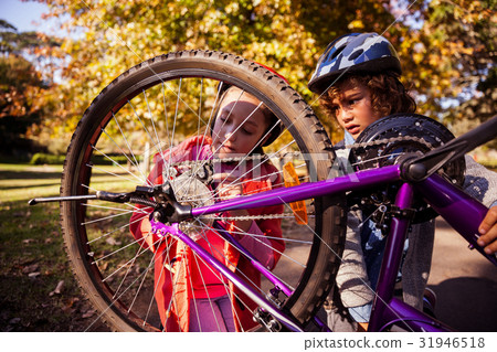 Concentrated siblings repairing mountain bike Concentrated siblings repairing mountain bike 31946518