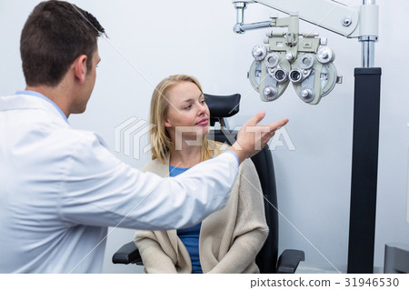 Optometrist interacting with female patient Optometrist interacting with female patient 31946530