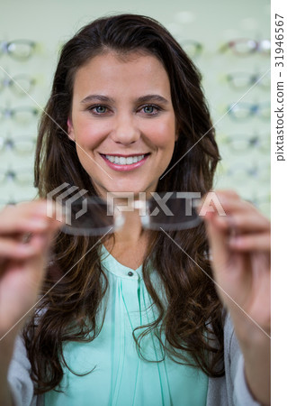 Female customer holding spectacles in optical store Female customer holding spectacles in optical store 31946567