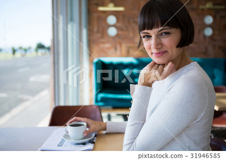 Smiling woman sitting in cafeteria 31946585