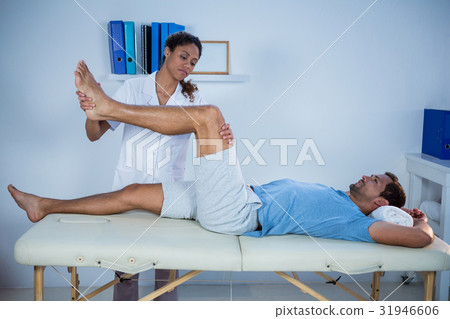 Physiotherapist giving leg massage to a patient Physiotherapist giving leg massage to a patient 31946606