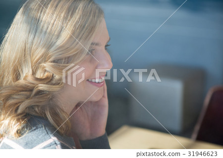 Smiling woman sitting in cafeteria 31946623