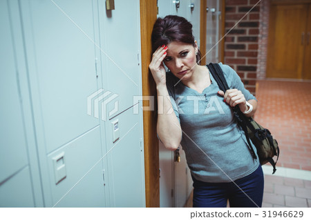 Stressed mature student standing in locker room 31946629