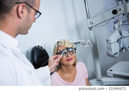 Optometrist examining female patient with messbrille Optometrist examining female patient with messbrille 31946672