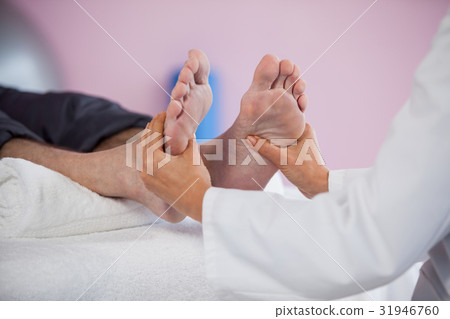 Senior man receiving foot massage from physiotherapist Senior man receiving foot massage from physiotherapist 31946760