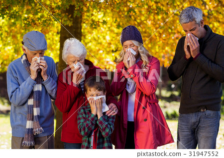 Sick family blowing their noses at park Sick family blowing their noses at park 31947552