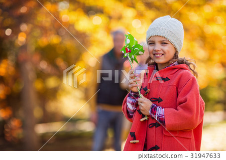 Cheerful girl with pinwheel toy at park 31947633