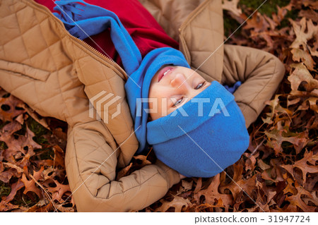 High angle view of boy lying at park during autumn High angle view of boy lying at park during autumn 31947724