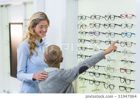 Mother and son selecting spectacles from display 31947864
