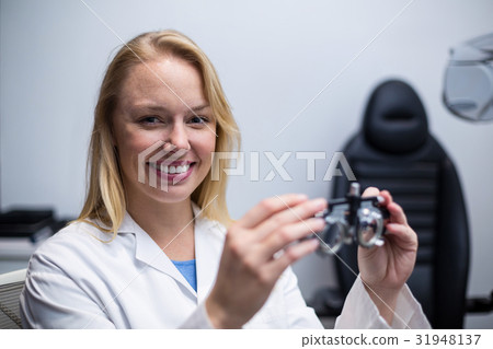 Smiling female optometrist holding messbrille Smiling female optometrist holding messbrille 31948137
