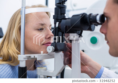 Optometrist examining female patient on slit lamp Optometrist examining female patient on slit lamp 31948252