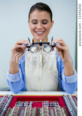Optician looking at trial frame Optician looking at trial frame 31948268