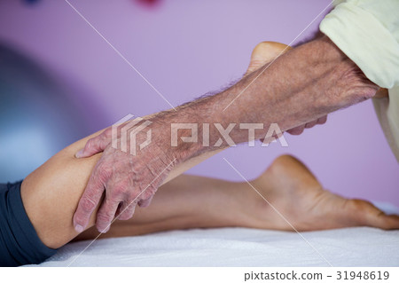 Physiotherapist giving leg massage to a woman 31948619
