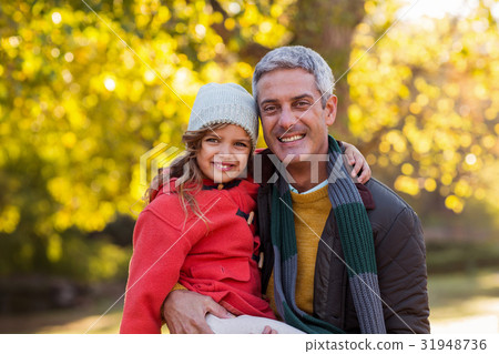 Father carrying daughter at park 31948736
