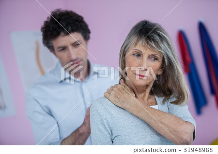 Physiotherapist giving neck massage to female patient 31948988