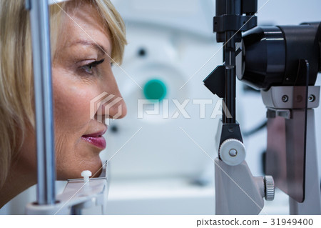 Female patient under going eye test on slit lamp 31949400