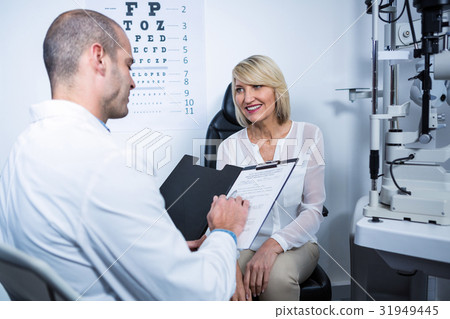 Male optometrist talking to female patient 31949445