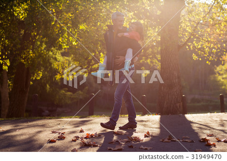 Father piggybacking daughter at park 31949470