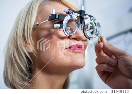 Optometrist examining female patient with messbrille Optometrist examining female patient with messbrille 31949513