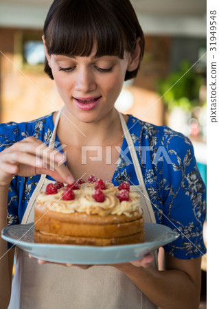 Waitress touching the cherry on the cake top 31949548
