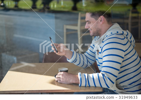 Man using mobile phone in the coffee shop 31949633