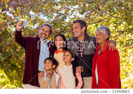 Multi-generation family taking selfie at park 31949661