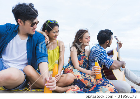 a portrait of a group of four friends sitting and relaxing on the beach a portrait of a group of four friends sitting and relaxing on the beach 31950178