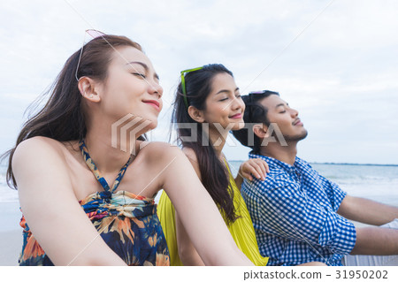 two women and man are sitting, closing their eyes and relaxing two women and man are sitting, closing their eyes and relaxing 31950202