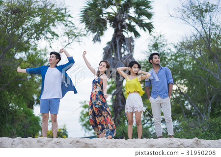 four male and female people are standing on the sand and relaxing four male and female people are standing on the sand and relaxing 31950208