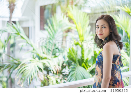 A photo of beautiful woman smiling and standing at balcony A photo of beautiful woman smiling and standing at balcony 31950255