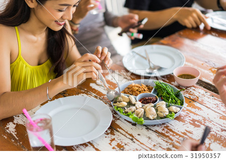 The girl is smiling and dining with her friends 31950357