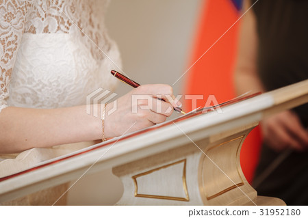 bride puts his signature pen in the registration bride puts his signature pen in the registration 31952180