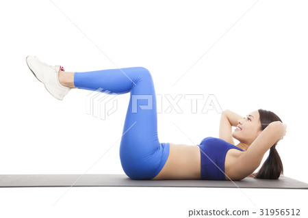 Fit blonde doing pilates core exercise in studio 31956512
