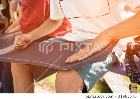 Boy glue the griptape on a skateboard 31963576