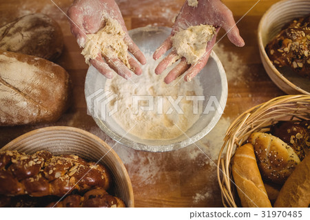 Hands of baker mixing flour by hand 31970485