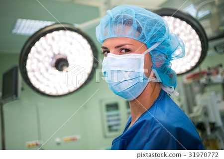 Portrait of a female surgeon wearing surgical mask and surgical cap 31970772