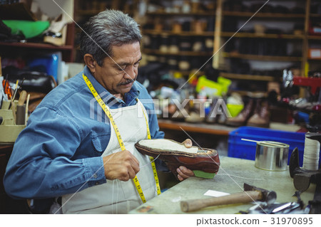 Shoemaker repairing a shoe 31970895