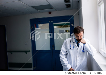 Sad doctor standing in corridor 31971063
