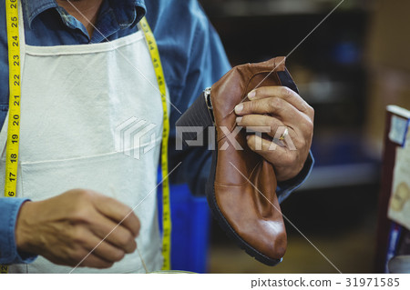 Shoemaker repairing a shoe 31971585